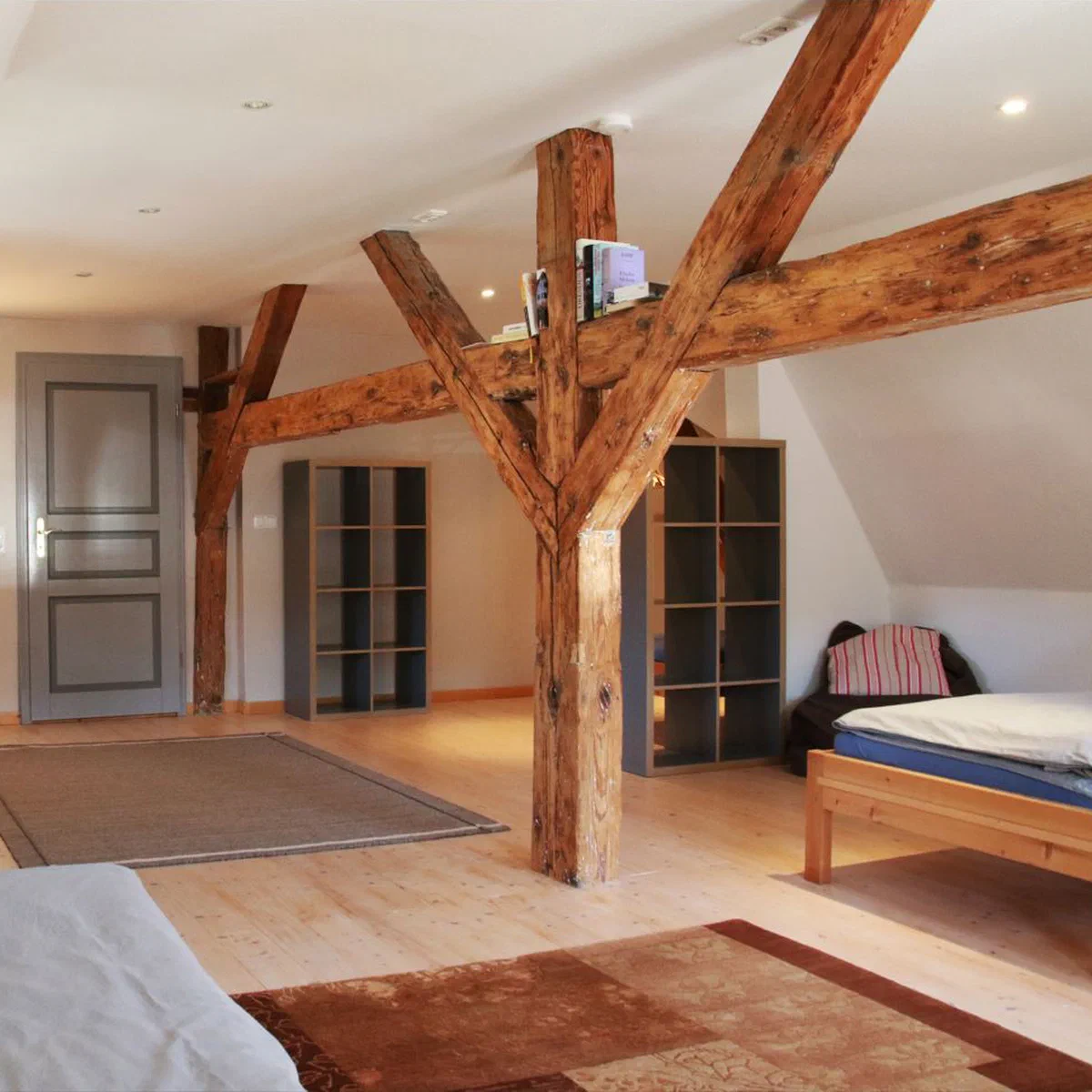 Dachgeschoss von Fewo 1 mit freiliegenden Holzbalken, Doppelbett und Sitzecke