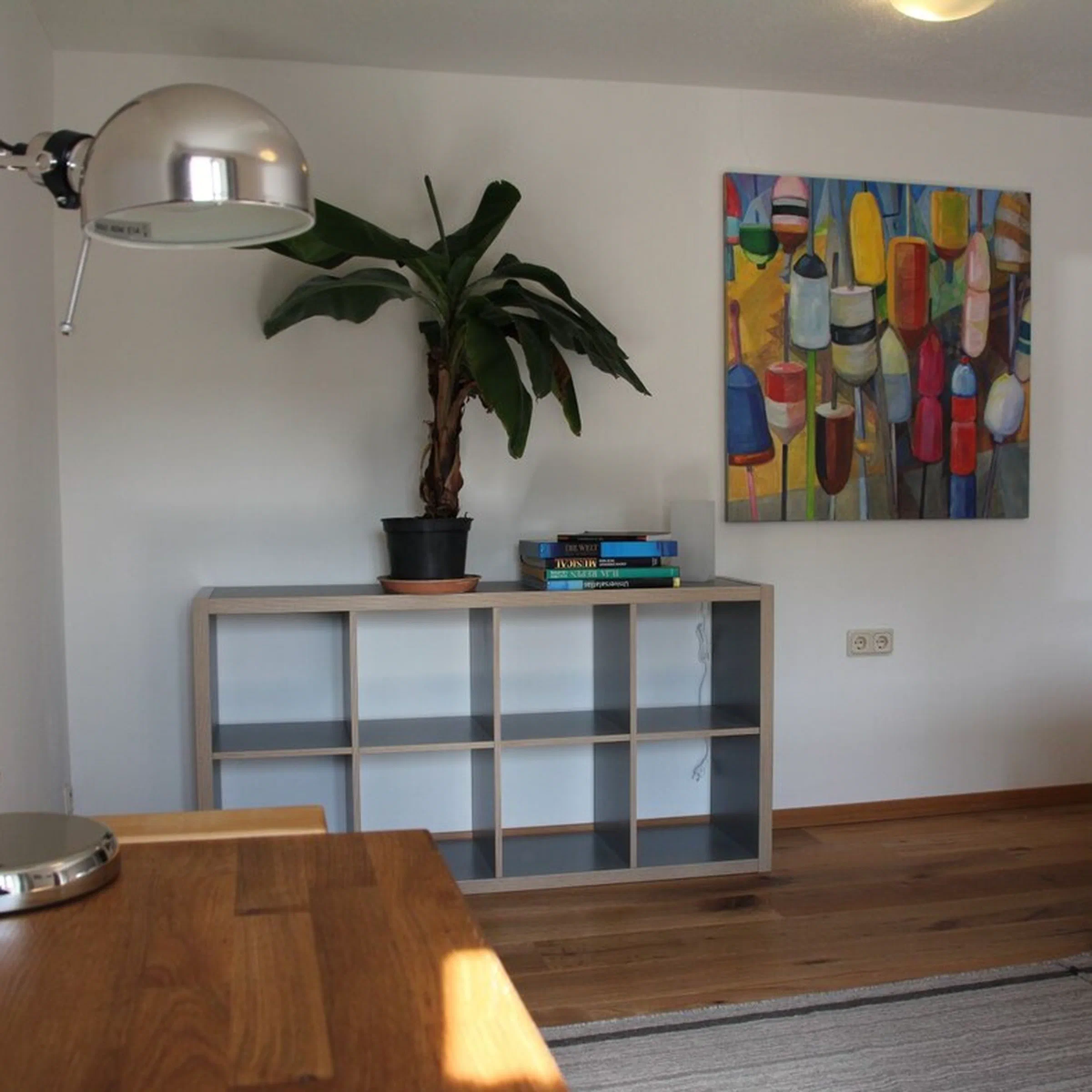 Sideboard mit Bananenpflanze und buntem Kunstdruck