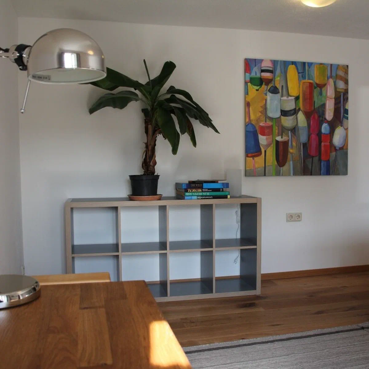 Sideboard mit Bananenpflanze und buntem Kunstdruck