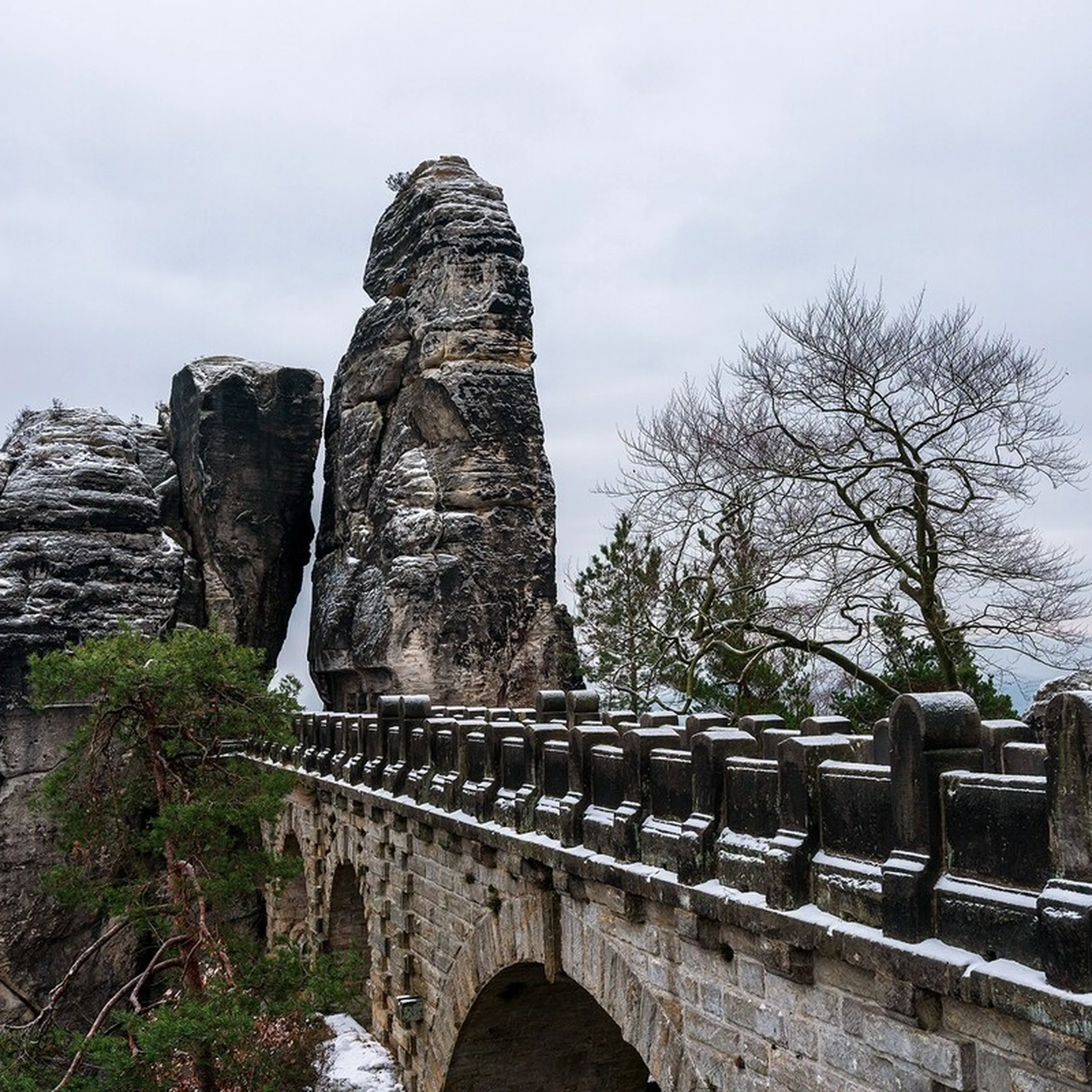 Basteibrücke im Winter mit schneebedeckten Felsformationen