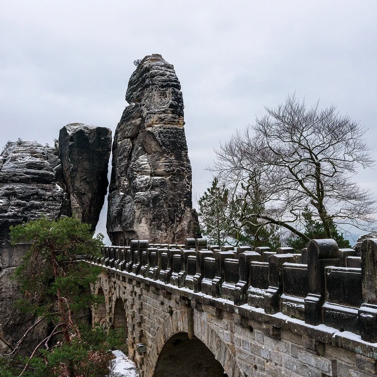 Basteibrücke im Winter mit schneebedeckten Felsformationen